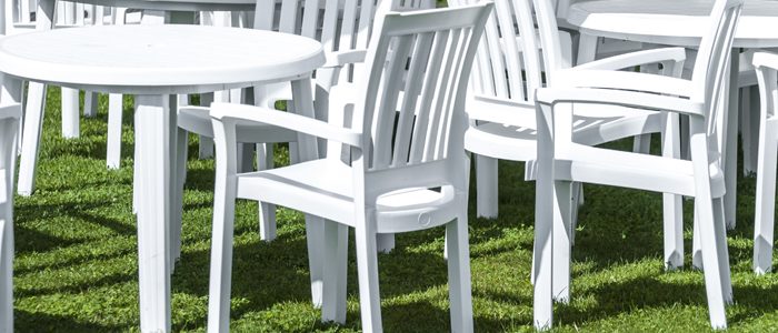 weiße Gartentische und -stühle auf einer Wiese