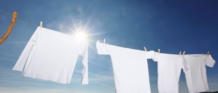 weiße Wäsche auf einer Leine vor blauem Himmel