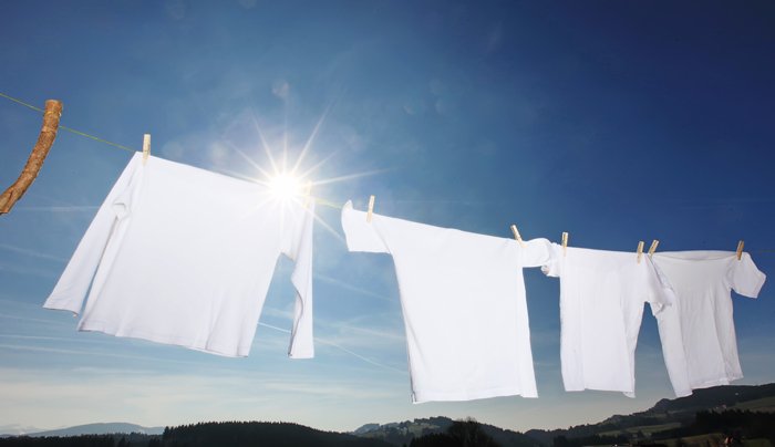weiße Wäsche auf einer Leine vor blauem Himmel