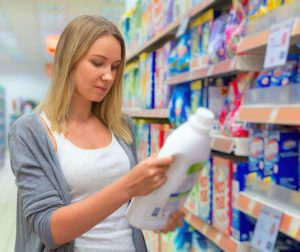 Frau liest Inhaltsstoffe der Waschmittelprodukte 