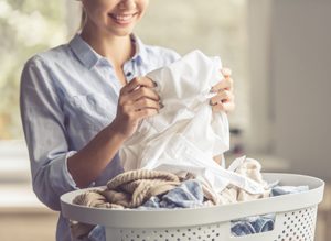 junge Frau freut sich über saubere Wäsche